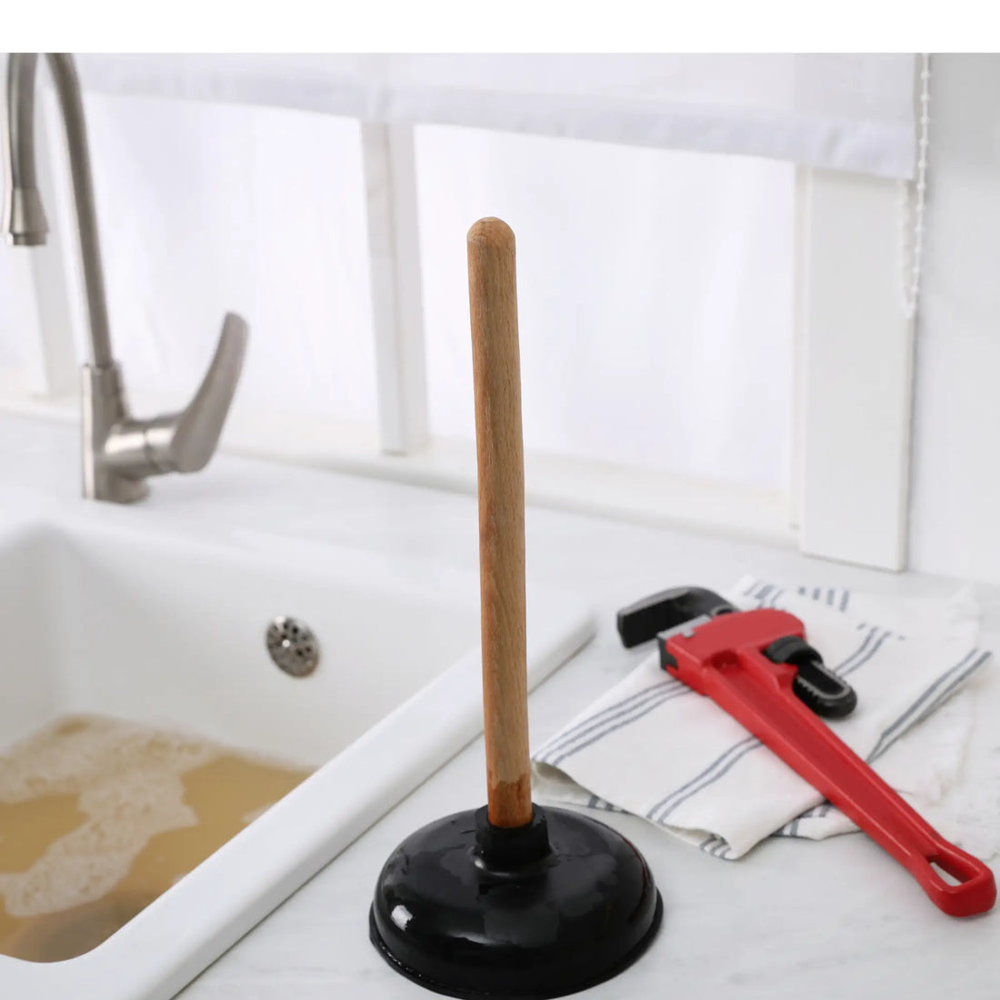Pilon de canalisation bouchée avec manche en bois, outil efficace pour déboucher.