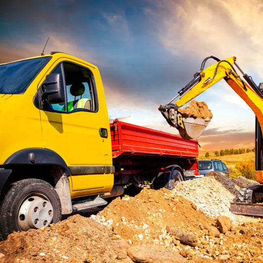 Image d’un camion benne jaune chargé de terre par une excavatrice pour pack chemisage canalisation terrassier-vrd-tp